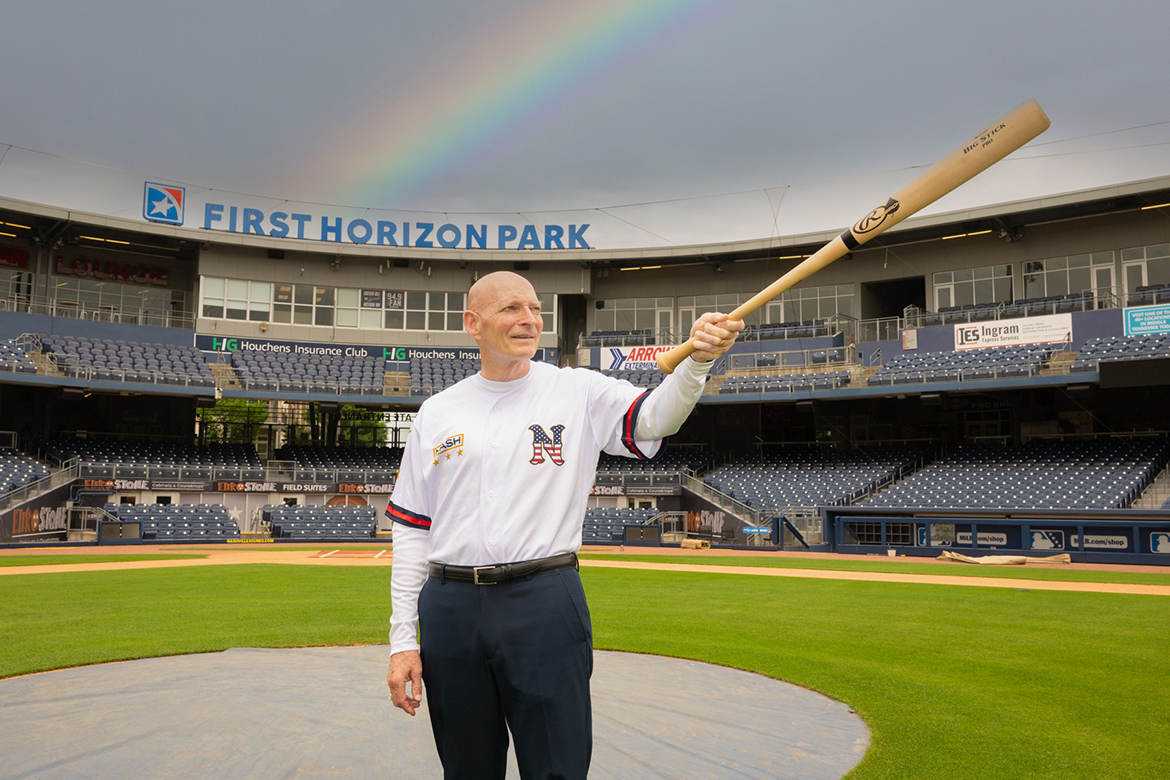 With a rainbow on display in the background, retired Lt. Gen. Keith Huber, center, senior adviser for veterans and leadership initiatives at Middle Tennessee State University, points a bat to the stands in this promotional photo on the field at First Horizon Park in Nashville, Tenn., home to the Sounds. Huber is wearing the special military jersey to be unveiled June 6 for the Sounds’ Military Appreciation Night and again on July 5 as part of the team’s Independence Day Weekend celebration. The game-worn jerseys will be auctioned, with proceeds benefitting the Charlie and Hazel Daniels Veterans and Military Family Center at MTSU. (MTSU photo by James Cessna)