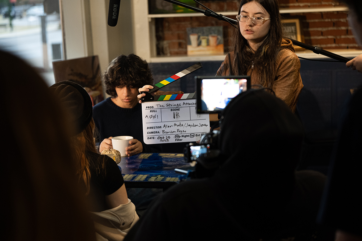 Smyrna High School student actor Gavin Averhoff, center left, student director Alan Mata, behind camera, and student actresses Ciara Robinson, left, and Marcail Dlouhy, right, work on set during the six-month production of the film “The Strings Attached” that included 150 shooting hours and four locations. (Photo courtesy of Kyle Dietz)