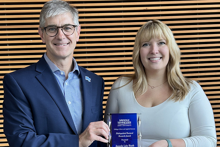 Amanda Lake Heath, Middle Tennessee State University doctoral student, receives the College of Basic and Applied Sciences’ Distinguished Doctoral Research Award from Dean Greg Van Patten in June 2024 at the MTSU Science Building in Murfreesboro, Tenn. (Submitted photo)