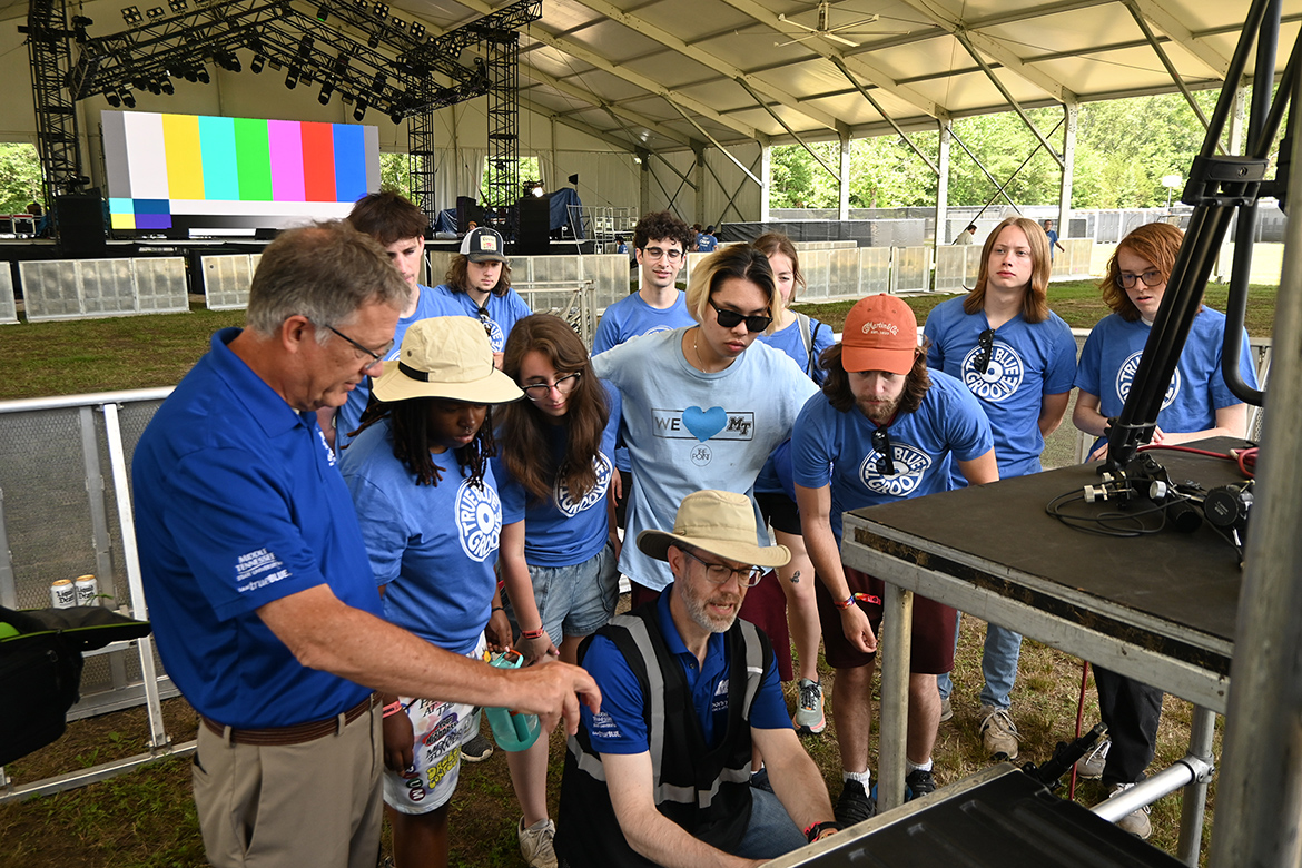 MTSU Provost Mark Byrnes, far left, joins Recording Industry professor Michael Fleming, kneeling, and his audio production students Wednesday, June 12, at the Bonnaroo Music and Arts Festival in Manchester, Tenn., as they prepare to broadcast concerts from the festival grounds on two of its five stages for the four-day event. (MTSU photo by Andrew Oppmann)
