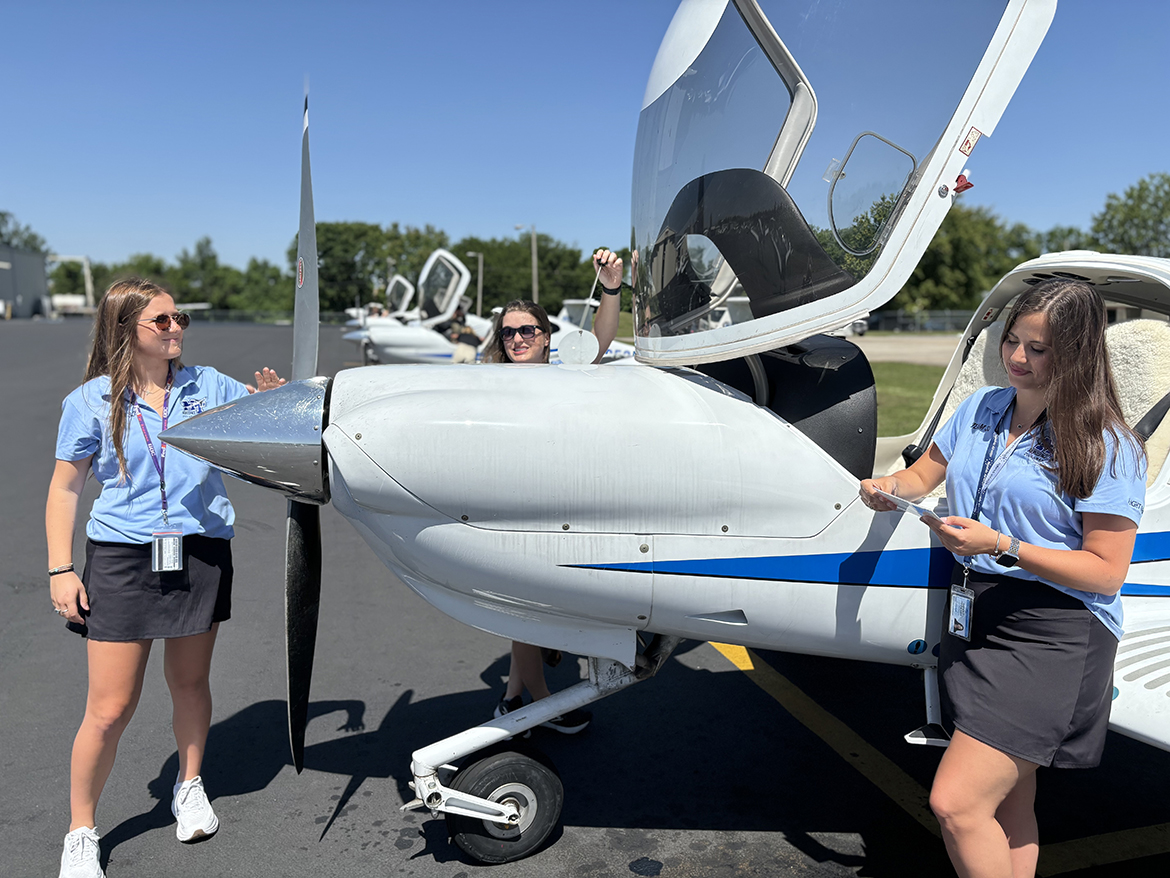 Middle Tennessee State University senior Hailey Harrison, left, checking the propeller, and alumna Alyssa Smith (checking the oil level) and Rachel Frankenberger (checking documentation) review key aspects of a flight before taking off at MTSU Flight Operations Center on Memorial Boulevard in Murfreesboro, Tenn. The trio will represent MTSU June 18-21 at the all-women Air Race Classic that goes nearly 2,400 miles from Carbondale, Ill., to Loveland, Colo. (MTSU photo by Randy Weiler)