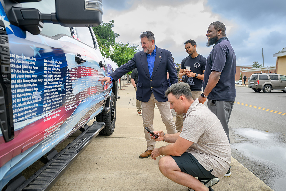 Rod Key, left, Middle Tennessee State University alumnus, a U.S. Marine Corps veteran and military career adviser for the MTSU Career Center, points to a veteran’s name on the Nashville Superspeedway Veterans Tribute Truck that visited the Murfreesboro, Tenn., campus, Thursday, June 27, as veterans Michael Kenney, Chris Rochelle and Matt Watkins of Premise Health take in the moment. The truck will be on display Friday through Sunday, June 28-30, next to the Charlie and Hazel Daniels Veterans and Military Family Center tent that’s part of the speedway’s Ally 400 race weekend events in the Family Zone at the track in Gladeville, Tenn. Rochelle is assistant director for the Daniels Center. (MTSU photo by J. Intintoli)