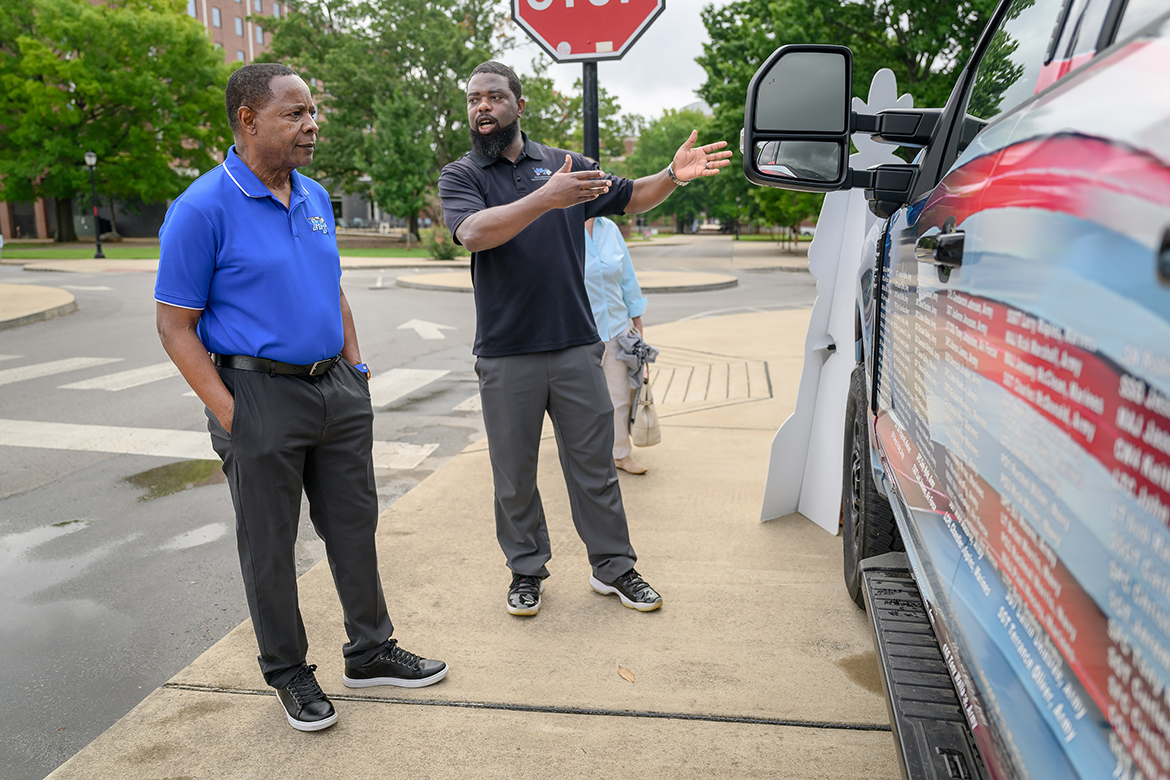 Middle Tennessee State University President Sidney A. McPhee, left, learns about the background behind the special Nashville Superspeedway Veterans Tribute Truck visiting the campus Thursday, June 27, in Murfreesboro, Tenn., from Chris Rochelle, a veteran and Charlie and Hazel Daniels Veterans and Military Family Center assistant director. The truck, featuring 132 names of veterans on the hood and driver’s side panels, will be a part of the NASCAR Ally 400 race weekend events at the track in Gladeville, Tenn., Friday through Sunday, June 28-30. (MTSU photo by J. Intintoli)