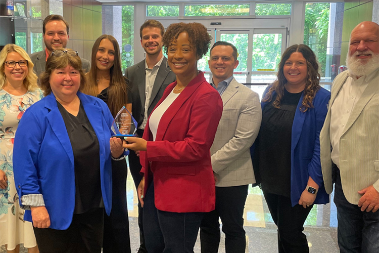 Carol Swayze, left, director of Experiential Learning at Middle Tennessee State University, presents the 2023-24 EXL Outstanding Community Award to Ashley Golson, front center, senior vice president of the National Sales Desk at Jackson Financial Services in Murfreesboro, Tenn. At far right is Thom Coats, director of MTSU’s Center for Professional Selling, who nominated the company for the award. (Submitted photo)