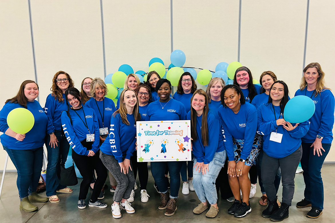 Middle Tennessee State University’s Home and Community-Based Early Intervention Program staff pose for a group photo at the Middle Regional Time for Teaming Conference on April 11, 2024, at the Wilson County Fairgrounds Expo Center in Lebanon, Tenn. At center, holding sign, is program director, Sharon Scott. (Submitted photo)