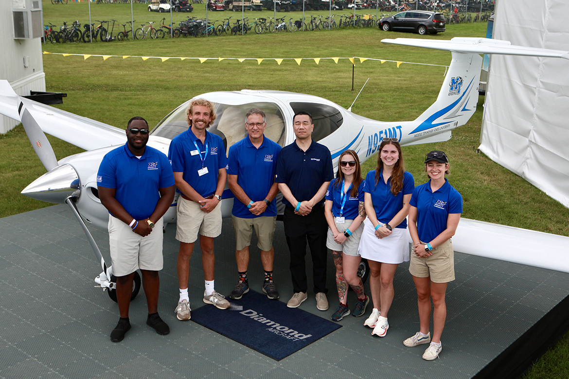 Middle Tennessee State University Provost Mark Byrnes, center left, and Diamond Aircraft CEO Frank Zhang, center right, pose with Middle Tennessee State University Aerospace students and flight instructors in front of one of MTSU’s DA-40 training aircraft, on display at Diamond’s booth at the 2024 EAA AirVenture, held annually in Oshkosh, Wisconsin. (Photo provided by Diamond Aircraft)