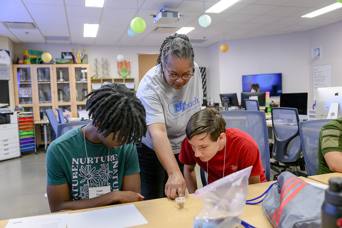 Fonya Crockett Scott, center,  Middle Tennessee State University MTeach master teacher, and College of Basic and Applied Sciences STEM Camp participants Liam Grant, left, and Zach Braddock, view their sample of worker termites in preparation  for an investigation on termite behavior — which way do they go? — recently in a Science Building classroom on the MTSU campus in Murfreesboro, Tenn. They were part of 40 students expanding their horizons in STEM — science, technology, engineering and math. (MTSU photo by J. Intintoli)