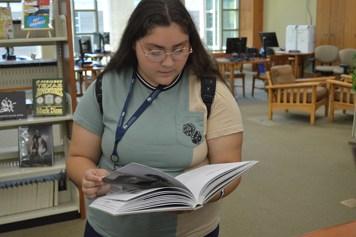 Ruby Fernandez of Shelbyville (Tenn.) Central High School examines at a book in the Motlow State Community College Library in Tullahoma, Tenn., during a recent Cultural Awareness Week visit as part of the Upward Bound program under Middle Tennessee State University’s Office of Student Success. Summer Academy participants also toured Austin Peay, Tennessee State and Fisk universities and Nashville State Community College. (Submitted photo)