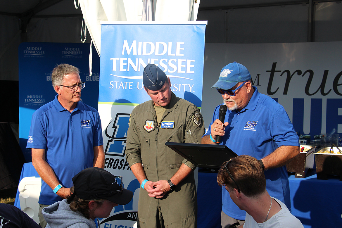 Middle Tennessee State University Vice President Andrew Oppmann, a Civil Air Patrol lieutenant colonel, reads a citation from MTSU President Sidney A. McPhee to Air Force Col. Aaron Reid, center, a graduate of MTSU’s aerospace program, while MTSU Provost Mark Byrnes, left, looks on. (MTSU photo by Brian Delaney)