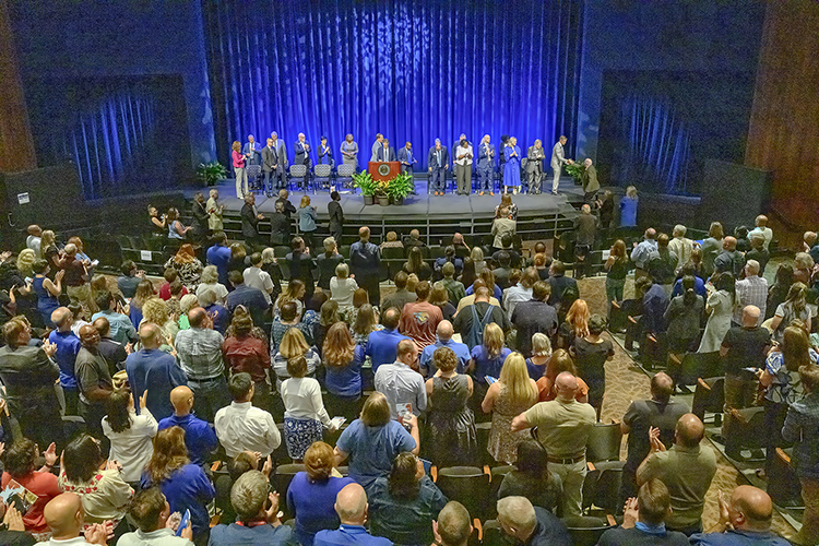 Middle Tennessee State University aerospace professor Paul Craig, at right ascending stage, shakes hands with College of Basic and Applied Sciences Dean Greg Van Patten as Craig receives a standing ovation as the MTSU Foundation’s Career Achievement Award recipient during the 2024 Fall Faculty and Staff Meeting held Thursday, Aug. 22, inside Tucker Theatre on the MTSU campus in Murfreesboro, Tenn. (MTSU photo by Andy Heidt)