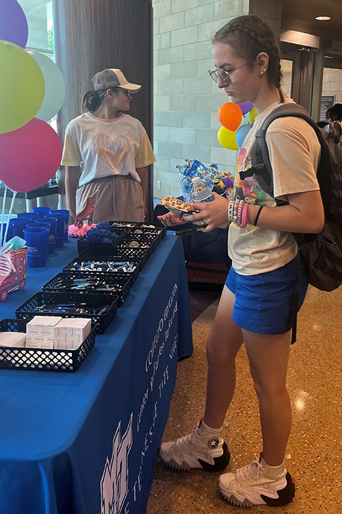 MTSU College of Education student stops at a booth at the "Rolling into Education!" welcome back event to grab free merch. (MTSU photo by Kristen Keene)