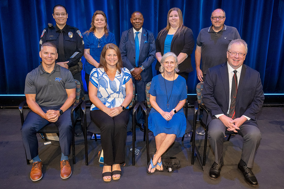 Middle Tennessee State University President Sidney A. McPhee, center, gathers at the annual Fall Faculty and Staff Meeting held Thursday, Aug. 22, with recipients of the President’s Silver Column Award, front row, from left, Chaney Mosley, associate professor and School of Agriculture director; ; Audrey Scarlata, associate professor of accounting; April Magnuson, Student Health Services clinical office manager; and Robert Gordon, media arts associate professor; and back row, from left, MTSU Police Sgt. Vergena Forbes; Teresa Thomas, Enrollment Technical Services director; MTSU President McPhee; Becca Smitty, MT One Stop director; and William Langston, psychology professor. Lisa Maas, associate vice president of Enterprise Application Systems, and Alison Ness, associate athletic trainer, were unable to attend the meeting to receive their awards. (MTSU photo by Andy Heidt)