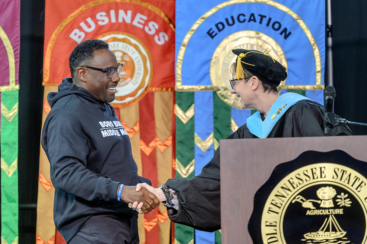 New Middle Tennessee State University football coach Derek Mason, left, is welcomed to the podium on stage during University Convocation by Laurie Witherow, vice provost for Enrollment Services Saturday, Aug. 24, in Murphy Center in Murfreesboro, Tenn., kicking off the fall semester and academic year that began Monday, Aug. 26. (MTSU photo by J. Intintoli)