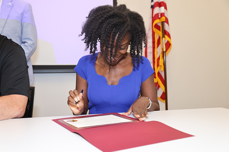 Middle Tennessee State University College of Education Dean Neporcha Cone signs a partnership certificate on July 29, 2024, at Nissan’s Partners in Education Signing Day event at the automaker’s manufacturing plant in Decherd, Tenn. The event celebrated the establishment of Nissan Centers of Excellence at nearby high schools to provide career technical training to those students. MTSU faculty is helping train Nissan employees to teach those courses full-time. (Submitted photo)