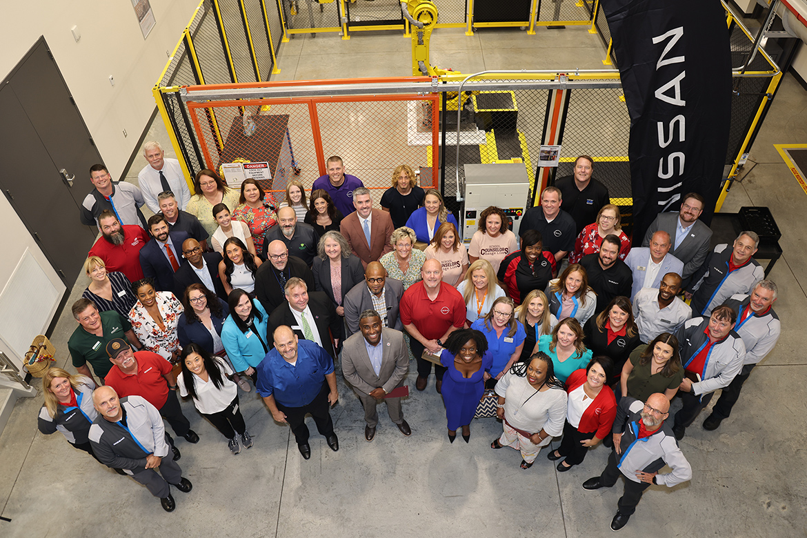 Middle Tennessee State University College of Education Dean Neporcha Cone, front center right in blue, is joined by other university representatives and a host of representatives from several community partners at Nissan’s Partners in Education Signing Day event at the automaker’s manufacturing plant in Decherd, Tenn., July 29, 2024. The event celebrated the establishment of Nissan Centers of Excellence at nearby high schools, in partnership with the Tennessee Board of Regents, to provide training to those students. MTSU education faculty is helping train Nissan employees to teach those courses full time. (Submitted photo)