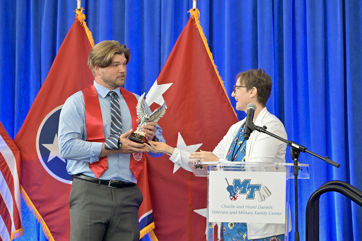 Ian Hedrick, left, of Murfreesboro, a Middle Tennessee State University graduating senior student veteran, receives the Veteran Leadership Award from Laurie Witherow, MTSU vice provost for Enrollment Services, Friday, Aug. 9, during the Graduating Veterans Stole Ceremony at the Miller Education Center on Bell Street in Murfreesboro, Tenn. (MTSU photo by Andy Heidt)