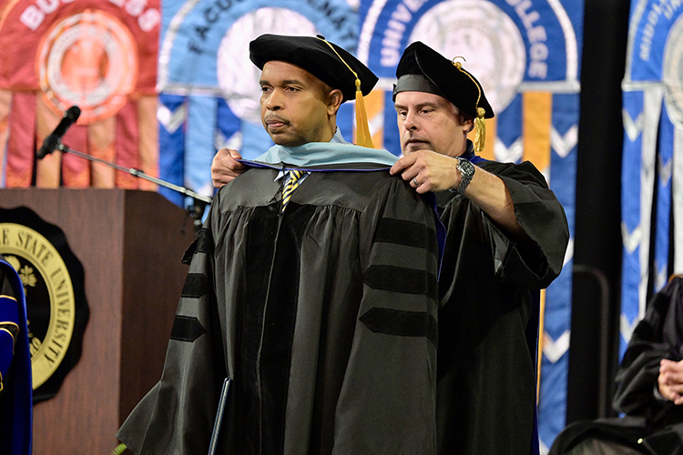 Middle Tennessee State University recording industry graduate Carlton Greene Sr., front, is hooded by assistant education professor Jim Rost, after earning his doctoral degree in Assessment, Learning and Student Success at the university’s summer 2024 commencement ceremony held Saturday, Aug. 10, inside Murphy Center on the MTSU campus in Murfreesboro, Tenn. More than 770 graduates received their degrees. (MTSU photo by Andy Heidt)