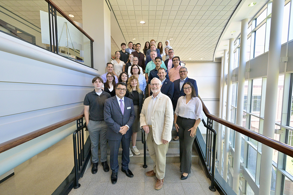 Murat Arik, second from left, holder of the Chair of Excellence in Regional and Urban Planning under the Jones College of Business at Middle Tennessee State University, and Paul Martin, COE-URP Advisory Committee chair, second from right, are pictured with other advisory committee members, MTSU faculty and the latest cohort of students participating in the COE-URP Scholars Program, inside the Business and Aerospace Building on the MTSU campus in Murfreesboro, Tenn. (MTSU photo by Andy Heidt)