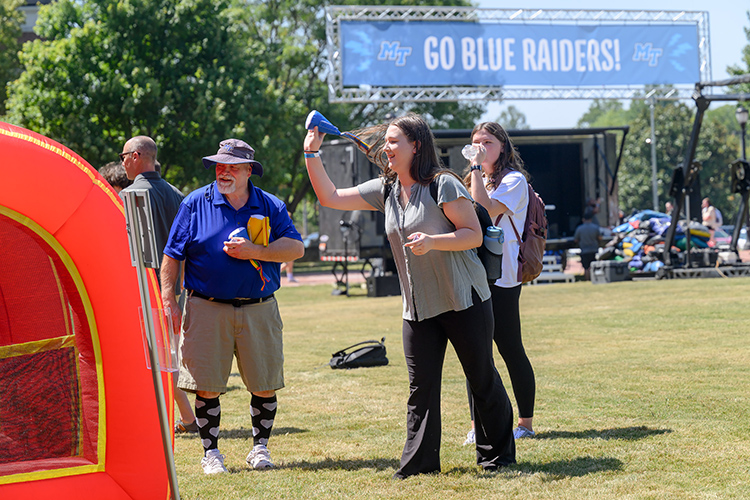 A Middle Tennessee State University student tries her at one of the various games available at the Back to School Bonanza held Aug. 26 on the Student Union Commons on the east side of the MTSU campus in Murfreesboro, Tenn. Looking on at left is Rich Kershaw, director of MTSU’s Student Programming and Activities. (MTSU photo by J. Intintoli)