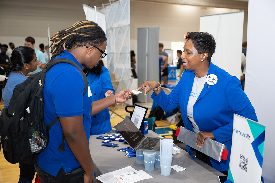 A Middle Tennessee State University student takes a business card from Chundra Davis, talent acquisition specialist from electric vehicle battery maker Ultium Cells, one of the 235 companies attending the Career Development Center’s 2024 Big Career Fair on Thursday, Sept. 26, inside the Campus Recreation Center in Murfreesboro, Tenn. (MTSU photo by James Cessna)