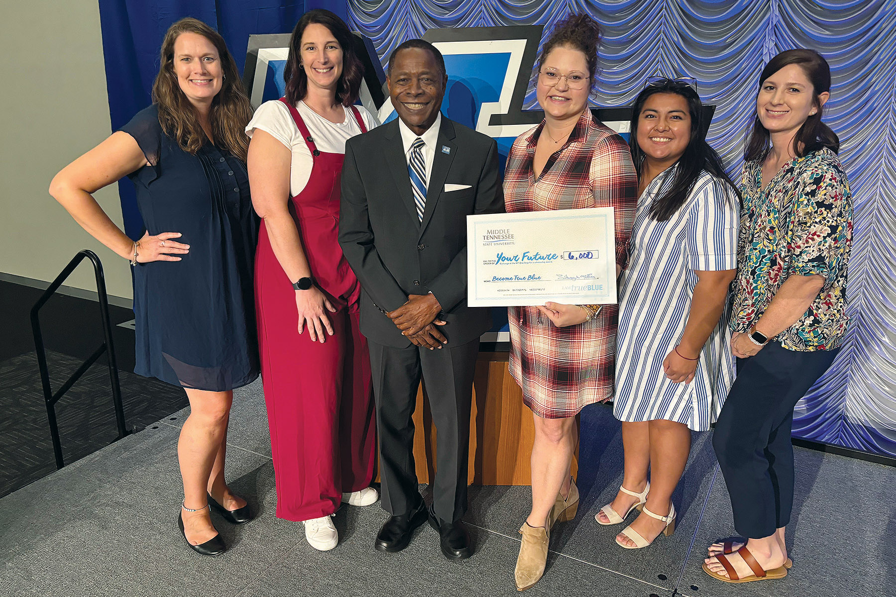 Middle Tennessee State University President Sidney A. McPhee, center, stands with counselors from Stewarts Creek High School, who walked away from the True Blue Tour kickoff luncheon with $6,000 in scholarship funds — double the amount given to the 43 other schools represented at the student recruitment event for high school counselors and community college advisors held Wednesday, Sept. 11, in the Student Union Ballroom on campus in Murfreesboro, Tenn. Pictured, from left, are Michelle Peterson, Lacey Campbell, McPhee, Christine Byrd, Jackie Garcia and Stephanie Oakes. (MTSU photo by Nancy DeGennaro)