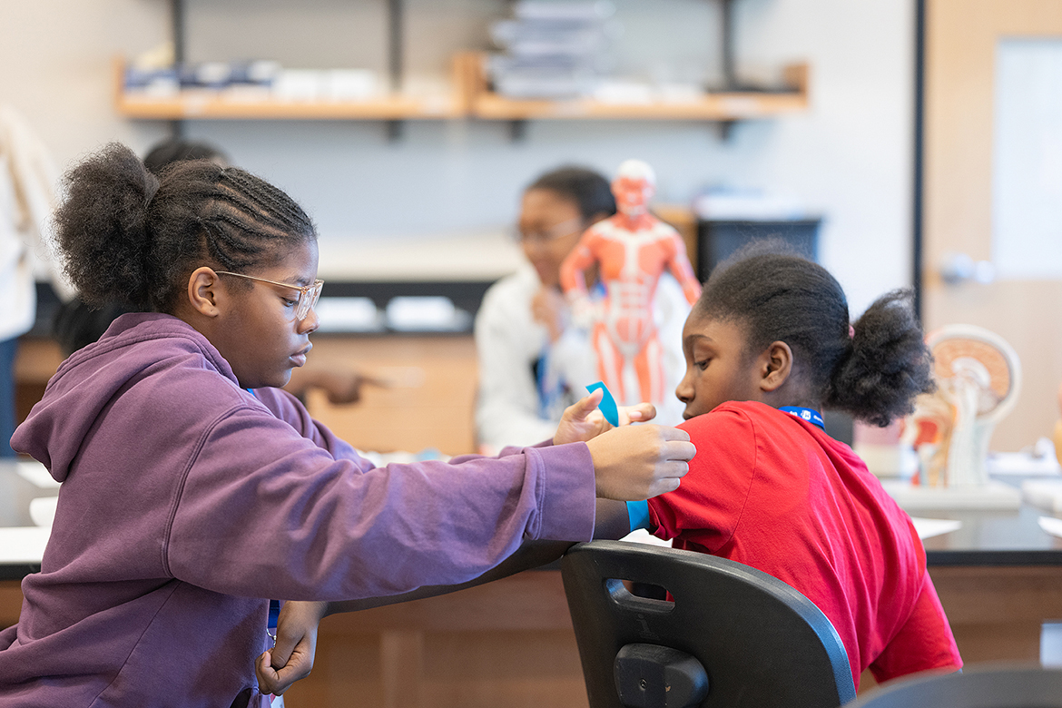 Bailey Fowler, left, of Nashville, Tenn., who is a Lipscomb Academy middle school student, and Israel Akins of Murfreesboro, a Siegel Middle School student, take turns making a tourniquet Saturday, Oct. 19, during the 28th annual Tennessee Girls in STEM Conference at Middle Tennessee State University in Murfreesboro. The session was led by Murfreesboro Medical Clinic lab technicians Mandy Keen and Michelle Cox. (MTSU photo by Cat Curtis Murphy)