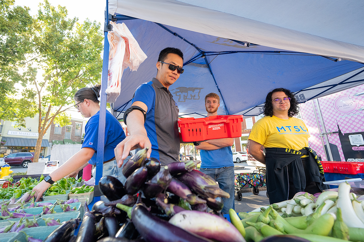 From left, Middle Tennessee State University student Hannah Harrell, professor Song Cui and students Tyler Lansford and Harlan “Dallas” Rogers provide certified organic produce for the buying public Oct. 12 at the Murfreesboro Saturday Market. The MTSU Small Farm group provides produce at the market during the spring, summer and fall months and will return Oct. 19 and Oct. 26 as the season winds to a close. (MTSU photo by Cat Curtis Murphy)