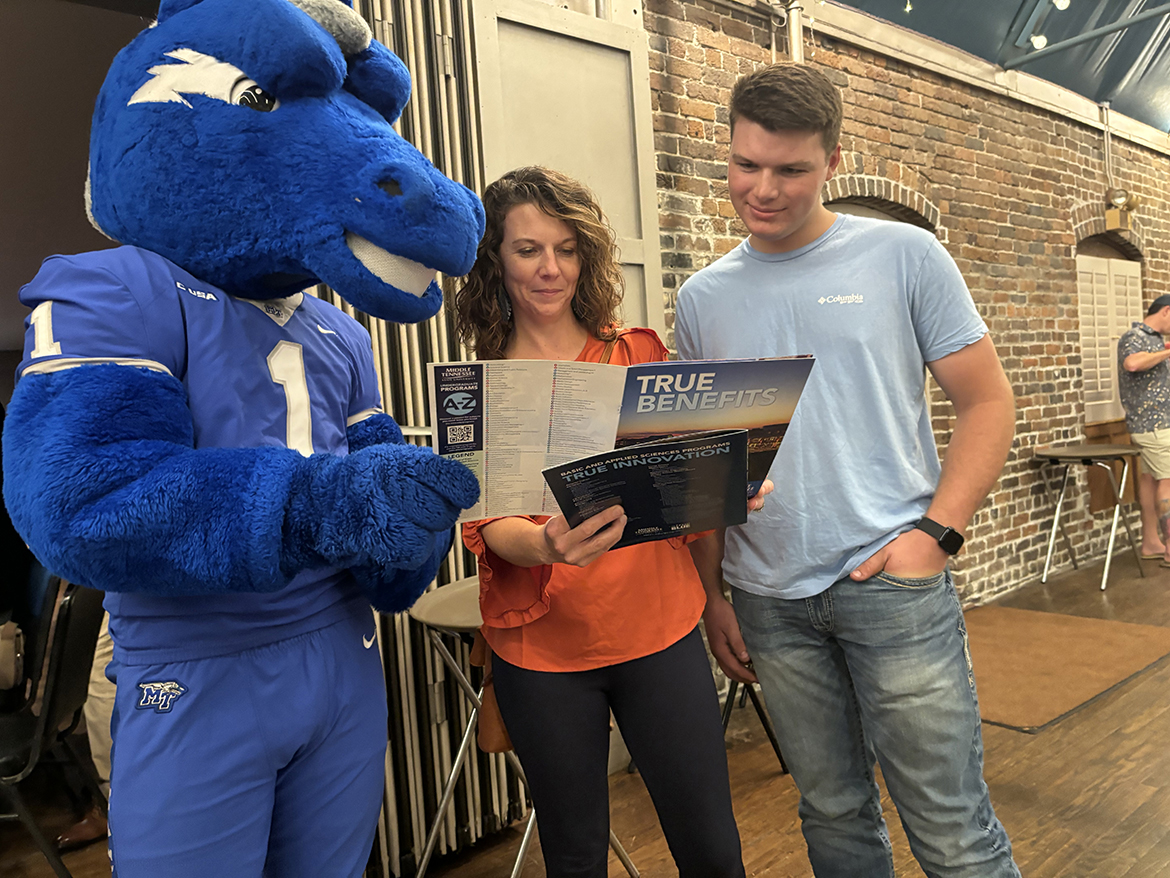 With “assistance” from Blue Raider mascot Lightning, left, Amanda Hansel and her son, Jefferson County High School senior Wayne Hansel, of Dandridge, Tenn., browse through a Middle Tennessee State University College of Basic and Applied Sciences brochure Wednesday, Oct. 2, during the annual MTSU True Blue Tour stop at The Foundry on the Fair Site in Knoxville, Tenn. More than 100 students and their parents took in the event, learning about MTSU’s many offerings in nine colleges within the university. (MTSU photo by Randy Weiler)