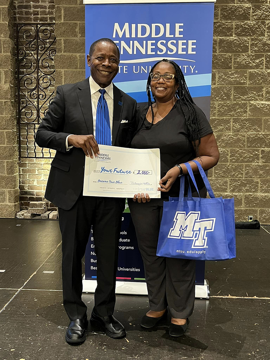 Middle Tennessee State University President Sidney A. McPhee, left, presents JoEllen M. DuBose of Knoxville, Tenn., with a $2,000 scholarship the aspiring nursing student can use to attend MTSU starting next year. The university provided $15,000 in financial aid to 10 Knoxville-area students attending the Oct. 2 True Blue Tour event at The Foundry on the Fair Site and more than $192,000 for counselors and community college staff to award to their students. (MTSU photo by Andrew Oppmann)