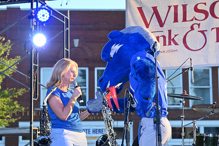 Sarah Callender, executive director of Main Street Murfreesboro, shares the stage with Middle Tennessee State University mascot Lightning at the October Friday Night Live concert in downtown Murfreesboro, Tenn. (MTSU photo by James Cessna)