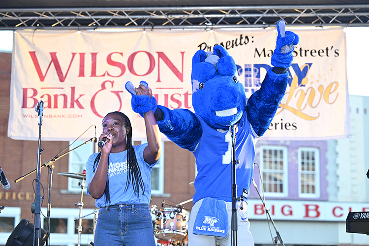 Chelsea Floyd, associate athletic director for marketing and fan engagement for Middle Tennessee State University Athletics, revs up the crowd with mascot Lightning from the stage at the October Friday Night Live concert in downtown Murfreesboro, Tenn. The event featuring MT Athletics was cosponsored by the university as part of a growing partnership with the Main Street Murfreesboro downtown advocacy organization. (MTSU photo by James Cessna)