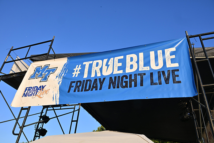 A True Blue banner is proudly displayed from the stage of the October Friday Night Live concert in downtown Murfreesboro, Tenn., an event co-sponsored by Middle Tennessee State University and its athletics programs as part of a growing partnership with the Main Street Murfreesboro downtown advocacy organization. (MTSU photo by James Cessna)