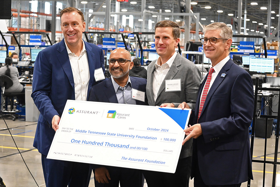 Representatives from Assurant Inc. present Greg Van Patten, far right, dean of Middle Tennessee State University’s College of Basic and Applied Sciences, with a ceremonial check representing the two-year $100,000 grant awarded to the university in support of its mechatronics engineering program and a new lab in the Applied Engineering Building set to open next fall on campus. Pictured at Assurant’s grand opening of its Mt. Juliet, Tenn., facility are, from left, Assurant representatives Keith Demmings, president and CEO; Biju Nair, executive vice president and president, Global Connected Living and International; Brandon Johnson, senior vice president, Global Supply Chain; and MTSU’s Van Patten. (MTSU photo by Jimmy Hart)