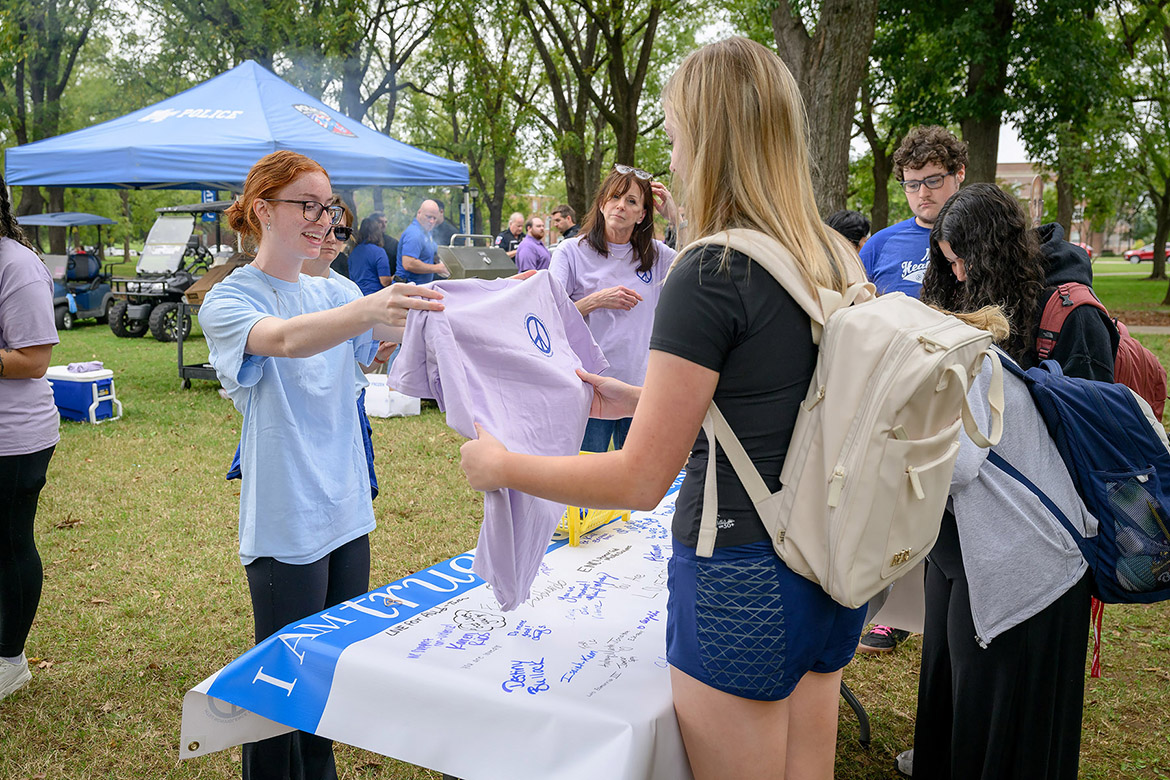 A Middle Tennessee State University student receives a free T-shirt after signing the Campus Nonviolence Committee’s banner that reaffirms the True Blue Pledge of committing to reason and not violence at the annual International Day of Nonviolence event on Wednesday Oct. 2, in Walnut Grove in Murfreesboro, Tenn. (MTSU photo by J. Intintoli)