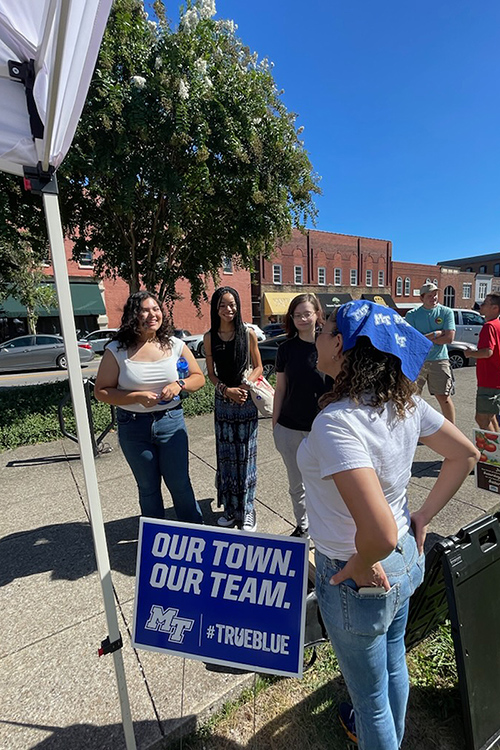 Monica Smith, right, assistant to the president for community engagement and inclusion at Middle Tennessee State University, greets students who took a shuttle from the Murfreesboro, Tenn., campus to the Downtown Farmer’s Market in September, part of a growing partnership between MTSU and the Main Street Murfreesboro downtown advocacy organization. (MTSU photo by Beth Loughry)