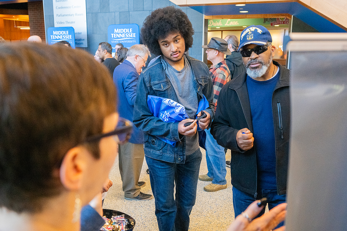 A prospective Middle Tennessee State University student, center, and his father learn about opportunities and offerings at MTSU during the Nov. 4 True Blue Preview day in the Student Union atrium on the MTSU campus in Murfreesboro, Tenn. A Sunday, Dec. 1, deadline looms for prospective students for the 2025-26 academic year to apply by to receive guaranteed scholarships. (MTSU photo by Cat Curtis Murphy)