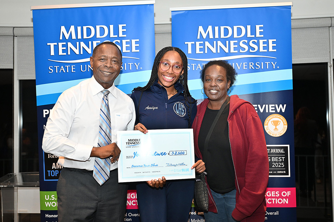 Middle Tennessee State University President Sidney A. McPhee, left, gives one of seven $2,500 scholarships to Beech High School senior Amiya Harris, who is joined by her mother Keisha Harris, right, at the MTSU True Blue Tour student recruitment event held Thursday, Nov. 7, at Gaylord Springs Golf Links club in Nashville, Tenn. (MTSU photo by James Cessna)