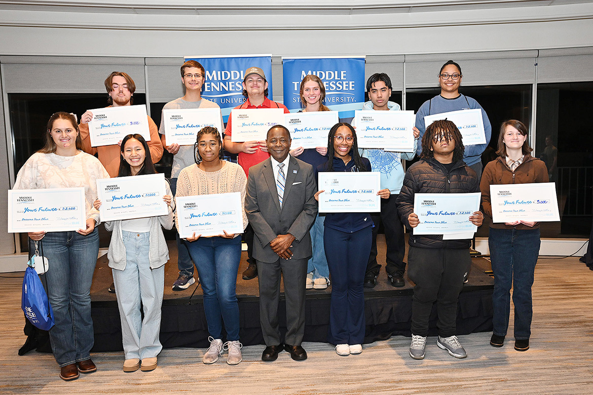 Middle Tennessee State University President Sidney A. McPhee, center on the front row, stands with the dozen students to receive a total of $29,000 in scholarships at the MTSU True Blue Tour student recruitment event held Thursday, Nov. 7, at Gaylord Springs Golf Links club in Nashville, Tenn. (MTSU photo by James Cessna)