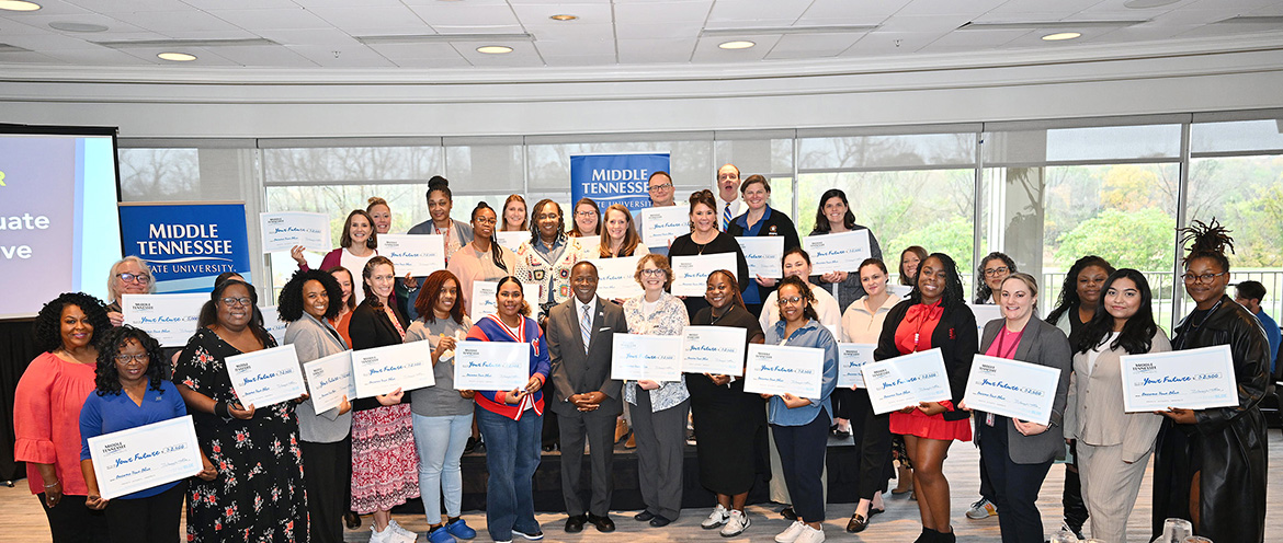 Middle Tennessee State University President Sidney A. McPhee stands with nearly three dozen high school counselors and community college advisors who were each given $2,500 scholarships to disperse future Blue Raiders at the True Blue Tour event held Thursday, Nov. 7, at Gaylord Springs Golf Links club in Nashville, Tenn. (MTSU photo by James Cessna)