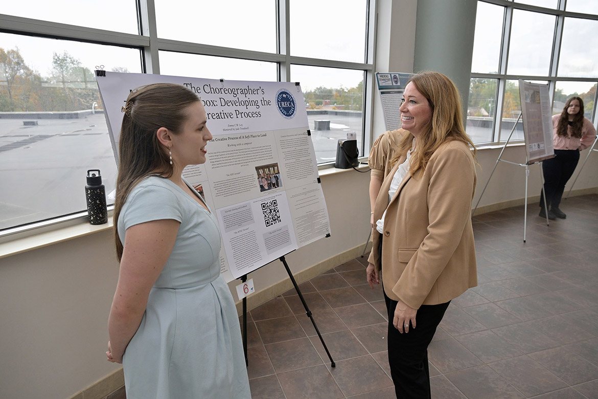 Middle Tennessee State University student researcher stands beside her research project as she talks with Jamie Burriss, director of the Undergraduate Research Center, at the center’s seventh annual Fall Research and Creative Activity Open House held Thursday, Nov. 7, in the Miller Education Center on campus in Murfreesboro, Tenn. (MTSU photo by Andy Heidt)