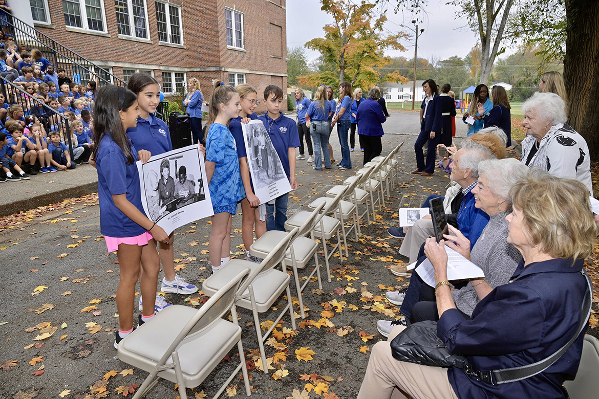 Homer Pittard Campus School students show Liz Whorley Bradley’s friend group, the “lollygaggers,” photos of Whorley Bradley during her time as Campus School’s principal from 1979 to 1985 at the unveiling of the two “Whorley Way” street signs situated at each end of the school’s driveway in Murfreesboro, Tenn. Middle Tennessee State University partnered with Friends of Campus School and Rutherford County Schools to plan and implement the street signs. (MTSU photo by Andy Heidt)