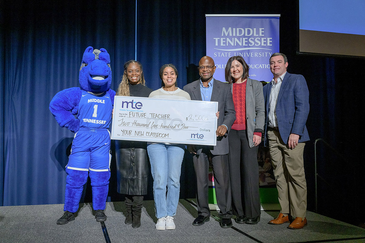 Middle Tennessee State University student Lyric James, third from left, a senior early childhood education major, holds the $2,500 Spark Award check she was presented Dec. 12 in the James Union Building on campus in Murfreesboro, Tenn. Middle Tennessee Electric awarded the College of Education $40,000 to outfit future teacher classrooms each semester for the next four years through the awards. Pictured, from left, are Lightning, the university’s mascot; Neporcha Cone, education dean; Robert White, MTE vice president of communications and member services; Larissa Westerfield, coordinator of teaching and learning for Rutherford County Schools’ instructional department; and Jay Sanders, MTE community relations coordinator. (MTSU photo by J. Intintoli)