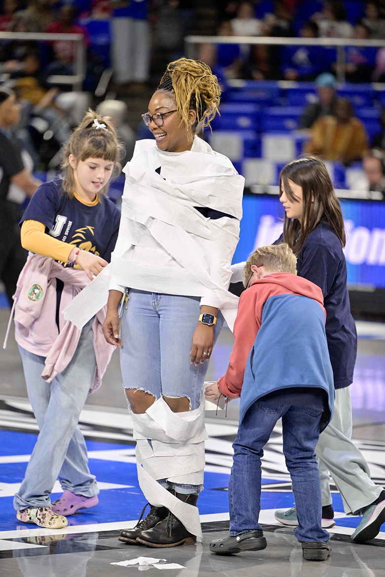 Murfreesboro City Schools’ students wind toilet paper around a teacher in the “Build a Snowman” competition during the annual Education Day game in Murphy Center on the Middle Tennessee State University campus Wednesday, Dec. 4, in Murfreesboro, Tenn. (MTSU photo by Andy Heidt)