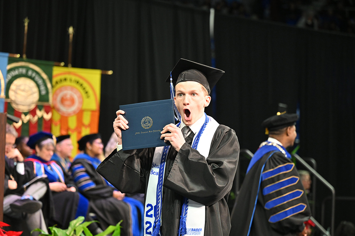 A Middle Tennessee State University student shows excitement as he holds up his newly obtained degree during the afternoon commencement ceremony held Saturday, Dec. 14, in Murphy Center on the MTSU campus in Murfreesboro, Tenn., for the fall graduating Class of 2024. Nearly 1,600 graduates received their degrees. (MTSU photo by Andy Heidt)