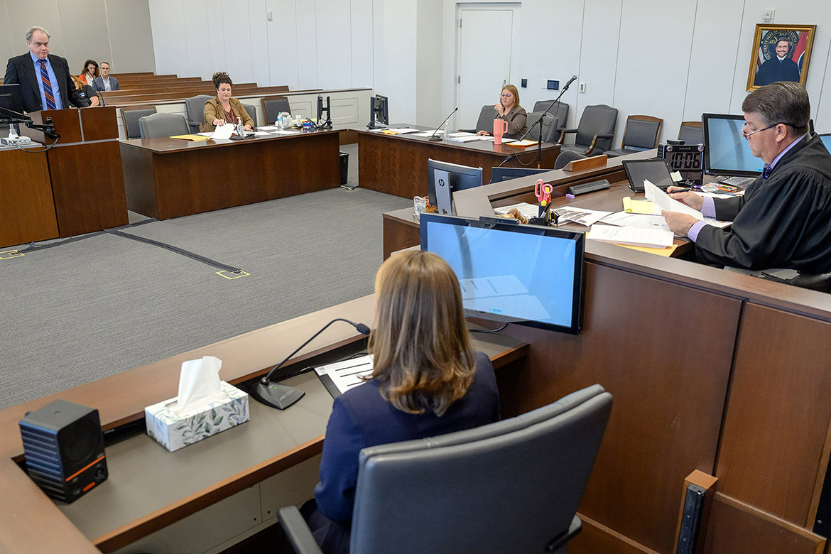 Rutherford County public defender Sean Williams, standing at the podium, questions Tracey Shepherd, a forensic science student at Middle Tennessee State University in Murfreesboro, Tenn., during a mock trial in the courtroom of Circuit Court Judge Barry Tidwell, seated on the bench, as Rutherford County Assistant District Attorney Allyson Abbott and MTSU adjunct instructor Andrea King read over case notes. (MTSU photo by J. Intintoli)