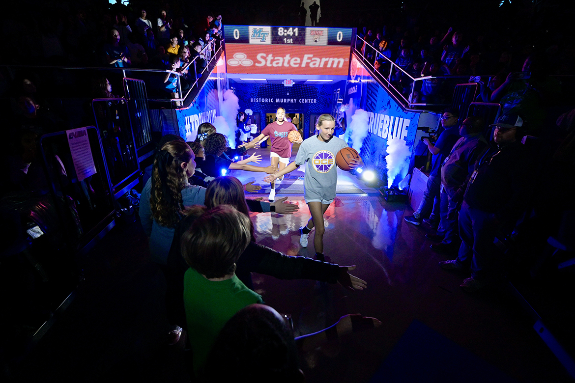 Wearing T-shirts from the Murfreesboro City Schools, Middle Tennessee State University women’s basketball players receive high-fives as they enter the court before the start of the annual Education Day game Wednesday, Dec. 4, in Murphy Center on the MTSU campus in Murfreesboro, Tenn. (MTSU photo by Andy Heidt)