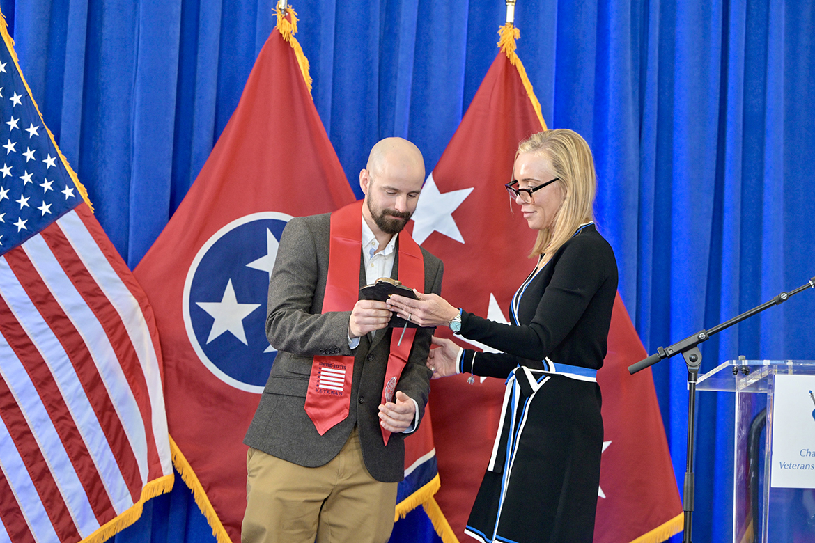 Middle Tennessee State University graduating senior veteran James Collins, left, of Clarksville, Tenn., accepts the Journey Award presented to him Thursday, Dec. 12, by Hilary Miller, director of the Charlie and Hazel Daniels Veterans and Military Family Center, during the annual fall Graduating Veterans Stole Ceremony at the Miller Education Center on Bell Street in Murfreesboro, Tenn. An English major in the College of Liberal Arts, Collins, a native of London, England, has the rare distinction of serving in the British Army and U.S. Army. (MTSU photo by Andy Heidt)