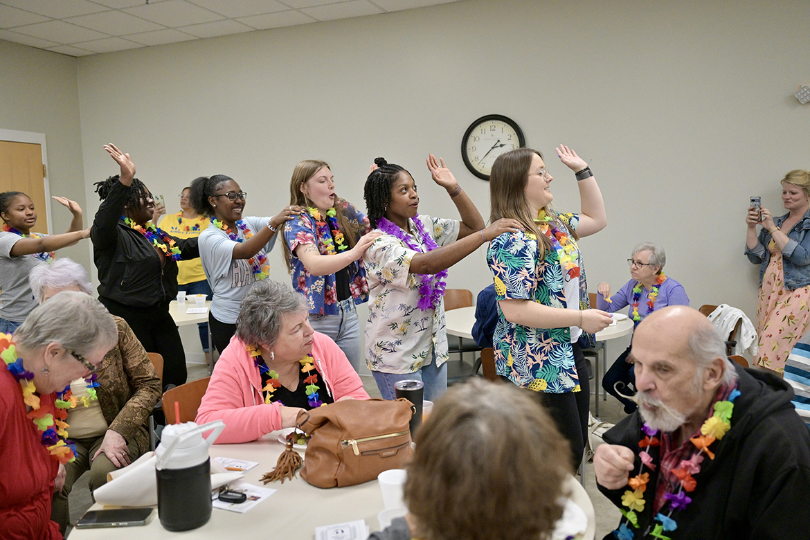 Students in the Aging Health and Development course at Middle Tennessee State University in Murfreesboro, Tenn., from left, Alexis Mason, Victoria Jennings, Katy Champion, Sydnee Washington and Kylie Calvert lead a dance train in the activity room of St. Clair Street Senior Center during a “cruise” party held as part of class on March 29, 2024. Each Friday during the semester, students taught by Human Development and Family Science lecturer Samantha Weir, seen at far right, plan and implement interactive games at St. Clair as well as Stones River Manor, also in Murfreesboro. (MTSU file photo by J. Intintoli)