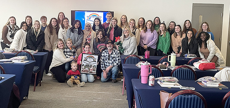 Family members of the late Middle Tennessee State University elementary education alumna Cassidy Ganey are gathered on the front row, from left, sister-in-law Liz Adair and her two children, daughter Piper Ganey, and parents Shirley and Kelly Vaughn, and surrounded by MTSU College of Education fall 2024 graduates. The family founded Cassidy Cares: Bookmarked from Heaven to honor the memory of Ganey, who died just three weeks after graduating from the program in 2018. The MTSU graduates received nearly two dozen books to help establish their first classroom libraries during a presentation held on campus on Dec. 12, 2024. (Submitted photo)