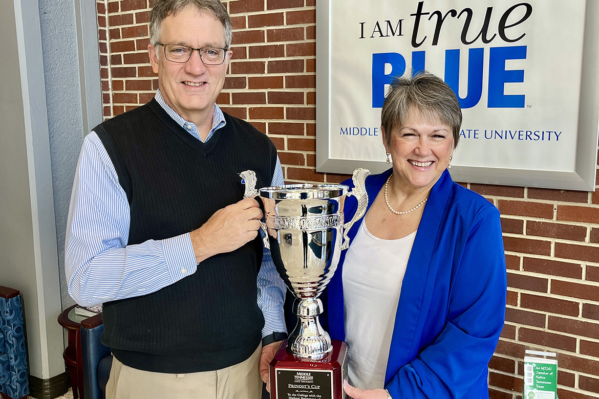 Middle Tennessee State University Provost Mark Byrnes, left, recently returns the Provost Cup to Joyce Heames, dean of the Jennings A. Jones College of Business, in the lobby of the Cope Administration Building on the MTSU campus in Murfreesboro, Tenn. For the 12th straight year, the Jones College was awarded the cup for having the highest percentage participation of faculty as part of the friendly competition among academic colleges during the annual Employee Charitable Giving Campaign. The 2024-25 campaign raised a record $161,000-plus in support of area nonprofits. (MTSU photo by Allison McGoffin)